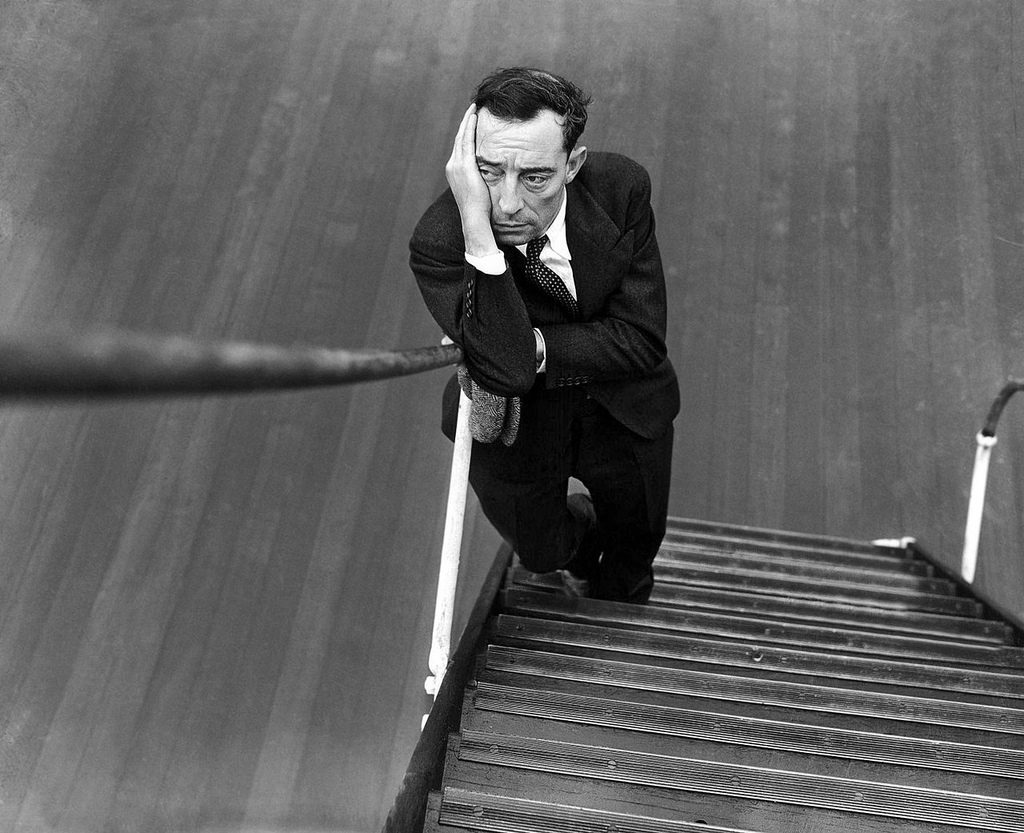 1934: If Buster Keaton was glad to be back in the United States, he certainly kept it a secret. The cameraman asked the film comedian to smile and this is the result. He was aboard the Ile de France on his return from a 5 months tour of the continent.