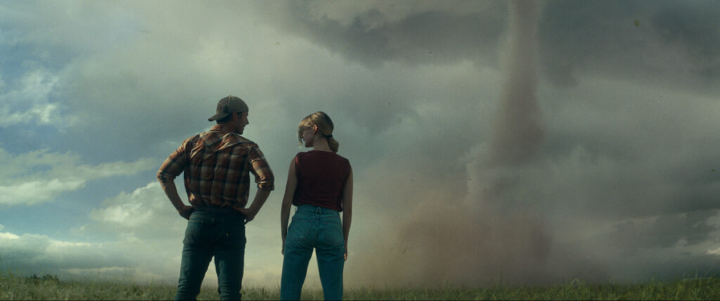 Glen Powell and Daisy Edgar-Jones watch dark skies in TWISTERS (2024)